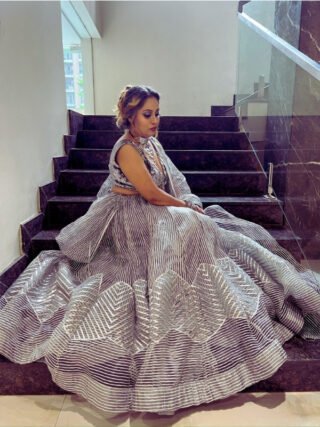 Designer silver sequin lehenga set with deep neck blouse, striped dupatta, and flowy skirt – perfect for weddings and parties.
