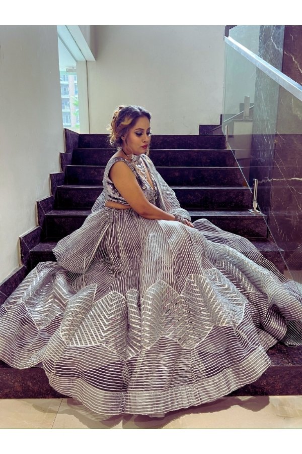 Designer silver sequin lehenga set with deep neck blouse, striped dupatta, and flowy skirt – perfect for weddings and parties.