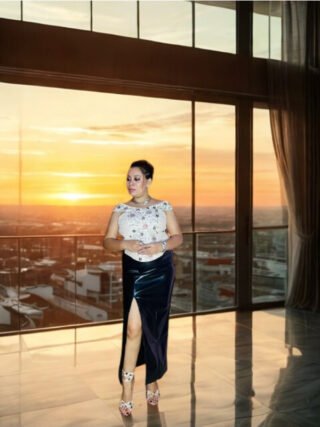 Woman wearing a floral embroidered off-shoulder corset top paired with a high-slit black skirt, styled for a bold and elegant fashion look – Melegant by LC.