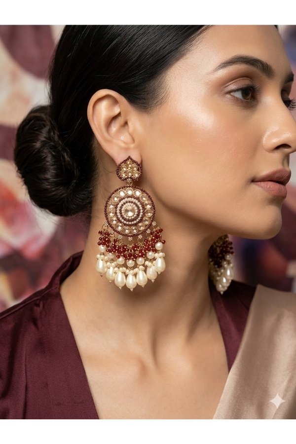 Maroon and gold Kundan Chandbali statement earrings with pearl drops worn by a model in an elegant silk outfit, from Melegant by LC