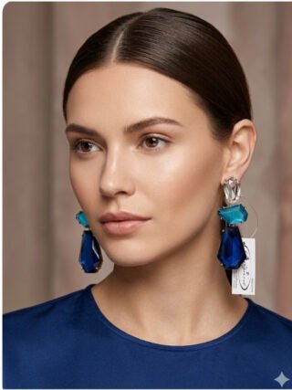 Close-up of a woman with a sleek bun wearing royal blue and turquoise tiered geometric crystal drop earrings from Melegant by LC,