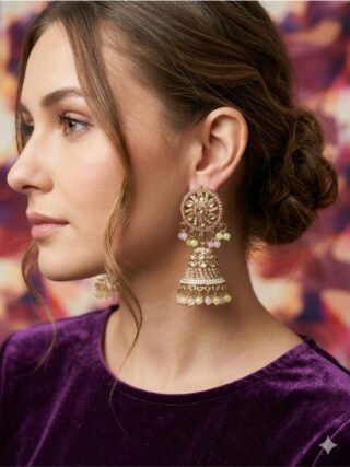 Model showcasing Melegant by LC traditional Kundan jhumka earrings featuring pastel pink and mint green beads with white pearl borders, paired with a purple velvet top