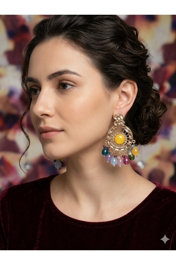 Model wearing Melegant by LC modern gold chandbali earrings featuring a bright yellow round center stone, crystal sunburst framing, and multi-color hanging gemstone beads against a dark maroon velvet top