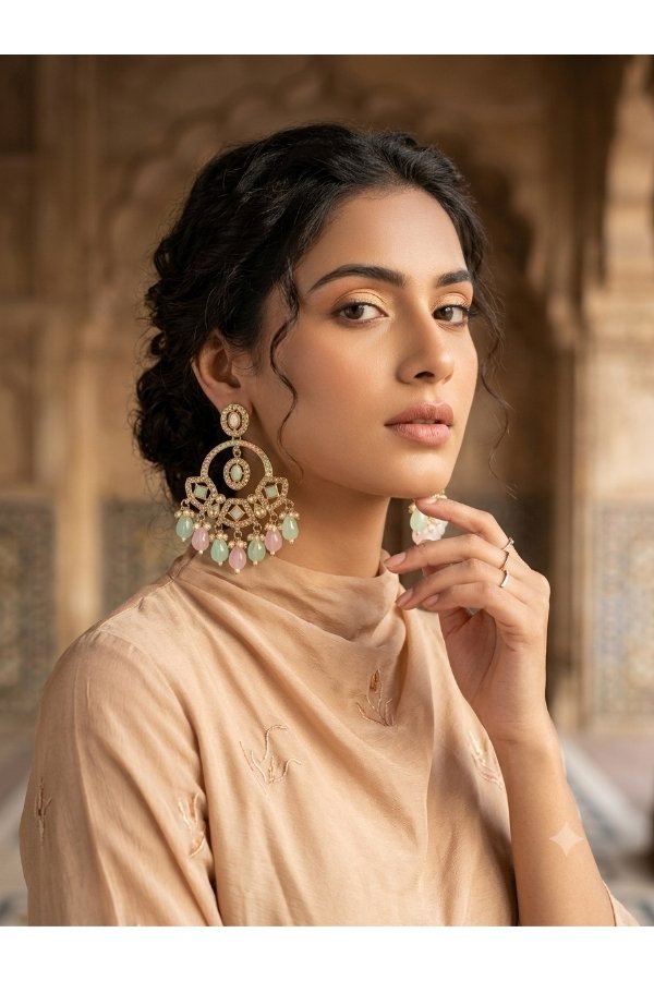 Pastel pink and mint green Kundan chandbali earrings displayed on a stand with Melegant by LC branding card for online shopping.