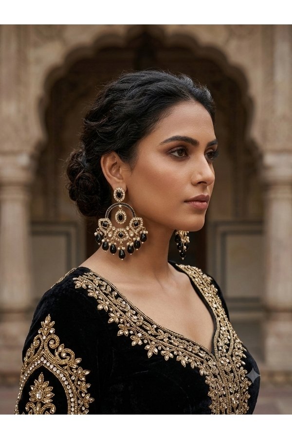 Model wearing luxurious black and gold Kundan chandbali earrings with an embroidered black outfit for Melegant by LC online store.